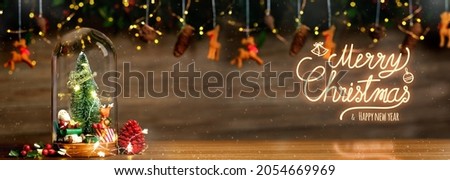 Merry Christmas and Happy new year xmas tree and santa claus in glass dome decor with bauble reindeer,pine cone tinsel at wood background Royalty-Free Stock Photo #2054669969