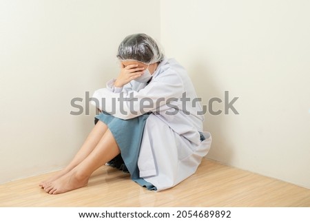Portrait of sadness worker woman crying sitting on floor at hospital after failure and tired from work because impact from covid-19 pandemic outbreak. medicine, healthcare and pandemic concept.
