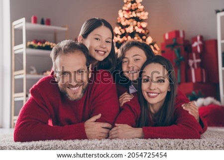 Photo of cheerful family have fun xmas atmosphere spirit winter decor parent kid lying floor indoors