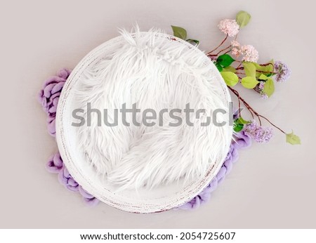 Beautiful backdrop for newborn photosession with flowers hydrangea. Digital composite with basin filled with knitted blanket isolated on light pink background Royalty-Free Stock Photo #2054725607