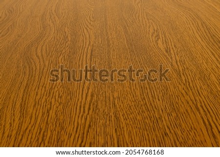 Wood grain pattern on the surface of the dark brown board