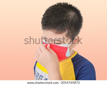 Boy wearing a double layer mask to prevent covid 19 virus on isolated background. The concept of wearing a double mask self defense 