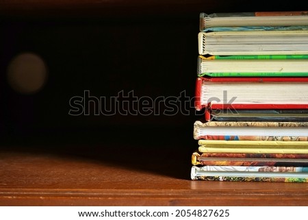 pile of books in wooden cabinet dark background with empty space for text and work , book stack , book ideas