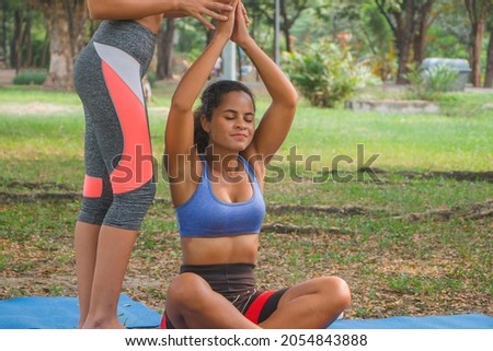 Fitness women practising yoga at a park. Women doing fitness workout in a park.