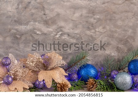 christmas composition in silver blue color, frame with blue garland and spruce branches on gray background, christmas balls and decorations, copy space. High quality photo