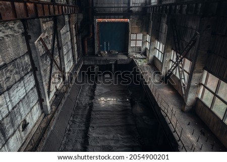 An empty room in an abandoned mining facility. Deserted space of an abandoned workshop covered with coal dust