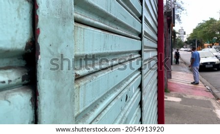 Closed store in street, urban sidewalk garage locked