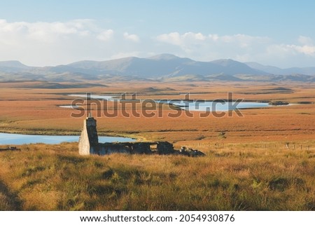 Old stone ruins of an abandoned bothy in the moorland mountain landscape on the Isle of Lewis and Harris in the Outer Hebrides, Scotland. Royalty-Free Stock Photo #2054930876
