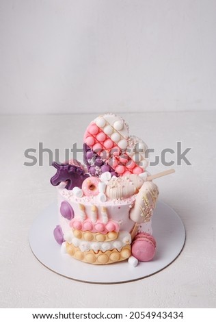 On a white background, a beautiful cake is decorated with children's toys