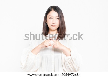Woman signing NG in front of white background