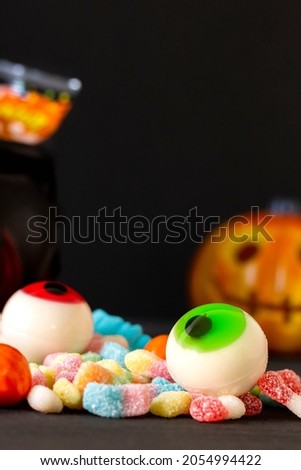 Scary orange pumpkin with delicious candies to celebrate Halloween, with a black background. Copy space, selective focus, concepts.