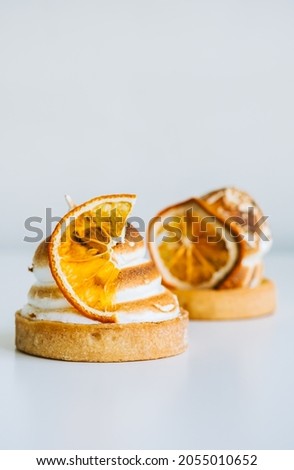 Lemon tartlet dessert with meringue on white background.