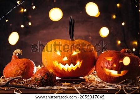 Jack O'Lantern stabbed with the knife with smoke behind as a background, decorated for halloween party