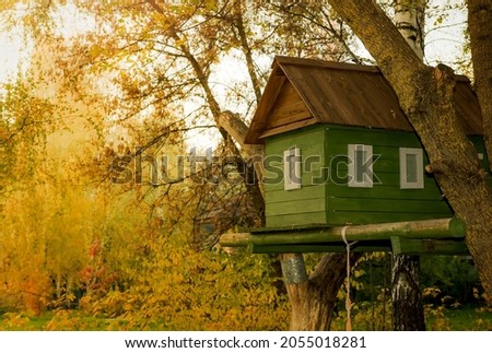 A small children's house for games and entertainment on a tree in the park. House on the branches of a large tree Royalty-Free Stock Photo #2055018281