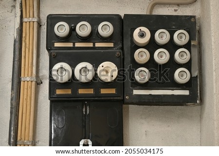 Old electrical fuse box with porcelain fuses in an older dwelling house, power and energy concept, selected focus Royalty-Free Stock Photo #2055034175