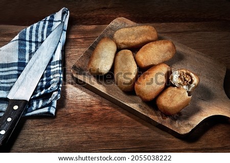 breads on a cutting board with knife and napkin. 
