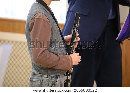 Music teacher teaching pupil with musical instrument in hand in school class at lesson.Close-up photo.Child development and education concept