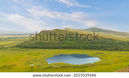 Mountain view the Second and Third Sunduki and a small lake at the foot. Landscape of the Sunduki mountain range located in the valley of the Bely Iyus River in Khakassia, Russia.