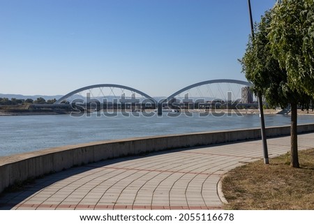Quay curve on the Danube river. The road-railway bridge has its curves. Like the Danube itself, which flows next to the city of Novi Sad. Royalty-Free Stock Photo #2055116678
