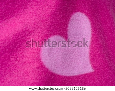 A pink heart on a pink blanket. Pink heart symbol.
