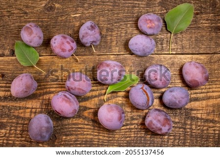 Fresh plums lying on a wooden table.Fresh, juicy fruits lying on a wooden table.