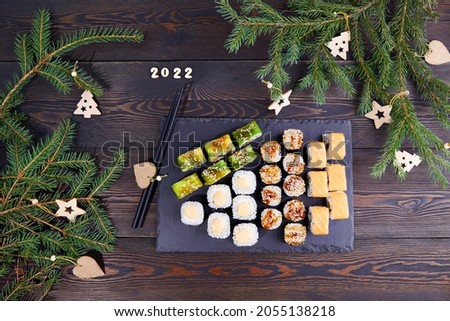 2022 Happy new year greeting banner. Big sushi set with tuna, salmon, eel, avocado, vegetables. 