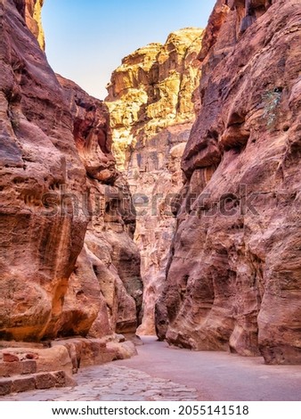 Picture with al-Siq, the natural passage through red rock walls which is main entrance to the ancient Nabatean city of Petra in southern Jordan.
