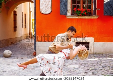 Lovely happy couple. Romantic portrait of married couple in love dancing in an old part of European city. Tenderness and love concept. Horizontal image.