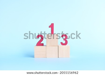 Podium, ranking and hierarchy concept. Wooden blocks with numbers 123 in blue background. Royalty-Free Stock Photo #2055156962