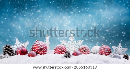 Beautiful Christmas background with red and white christmas balls and a blue snowy sky