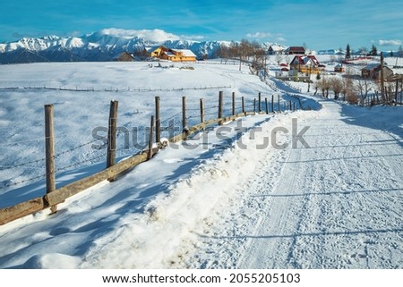 Fairytale winter landscape with alpine village and wonderful high snowy mountains, Pestera village, Romania, Europe