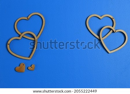 Hearts background. Valentine's Day decoration. Top view flatlay. Photo for children's party. Design of Greeting Card With 
wooden handmade figurines of hearts.Pastel trending colors