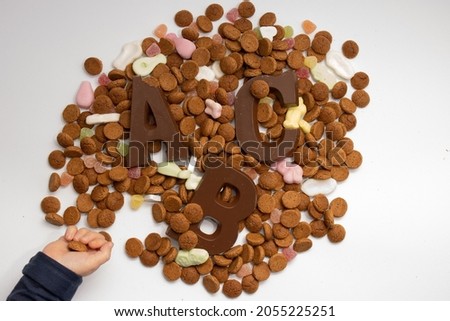 Child taking Pepernoten and Chocolate letters, typical Dutch candy Topview