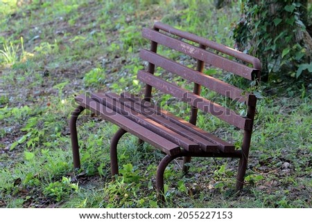 An old iron bench that is entirely rusted in reddish brown Royalty-Free Stock Photo #2055227153