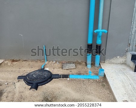 Gas Discharge System and Underground Sewage Storage Tanks. Underground tanks with black lids and black pipe fittings in waste collection systems. Royalty-Free Stock Photo #2055228374