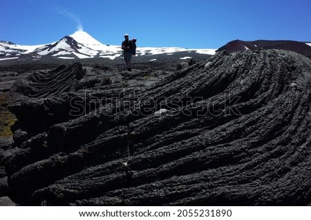 Active volcano, Trekking villarrica traverse hiking trail, Solidified lava from Villarrica volcano in Villarrica national park in Chile, Dark lifeless volcanic landscape in Patagonia Royalty-Free Stock Photo #2055231890