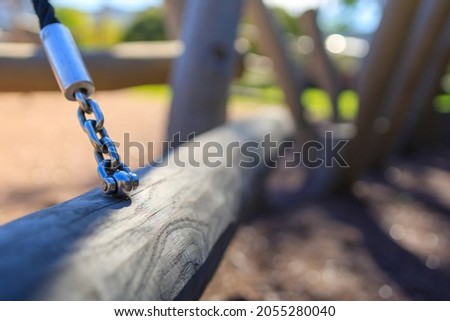 a rope with a metal chain supports the wooden structure