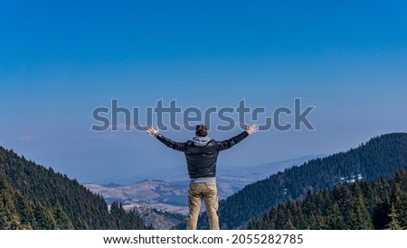 Beautiful sunny day scenery on mountain winter environment with a young attractive male person in his stylish clothes enjoying holidays on Serbian mountain ski resort. Sport and recreation. 