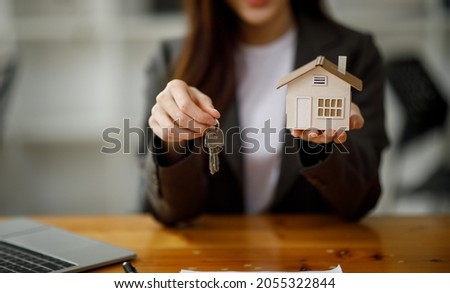 Real estate broker agent presenting and consult to the customer to decision making sign insurance form agreement, buy and sell home model, concerning mortgage loan offer for and house insurance