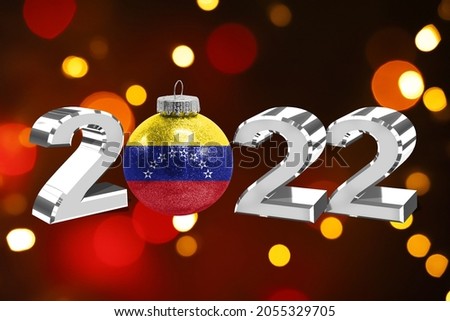 Colorful blurred background and applied the flag of Venezuela on the New Year's toy. New Year 2022 Celebration