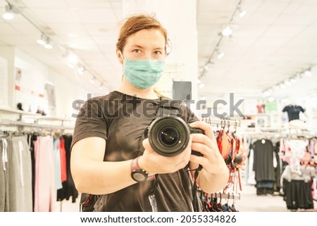 Camera self portrait. Big camera mirror photo at shop. Blur mall background. Green ecology mask. Zero waste people. Sad emotion