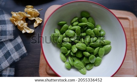 a bowl of fresh petai. "Petai or Pete", Bitter Beans, Parkia speciosa seeds. Petai is a type of vegetable that resembles sprouts with a distinctive aroma that enhances appetite. Top view