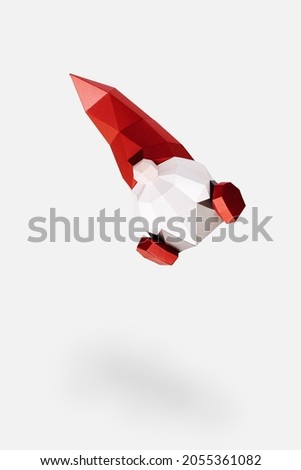 Volumetric paper Christmas gnome in red pointed hat on light, flying polygonal figure dwarf isolated on white background, Happy New Year and Merry Christmas holiday concept