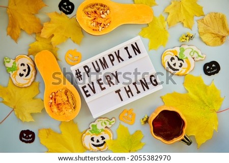 Beautiful text hashtag pumpkin everything among autumn decorations and food. Orange teacup with homemade cookies, fresh pumpkins, yellow leaves and decorations of pumpkins. High quality photo