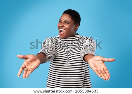 Come Here. Excited Overweight African American Woman Shouting Stretching Hands Looking At Camera Posing Over Blue Background In Studio. Give Me A Hug Concept Royalty-Free Stock Photo #2055384533