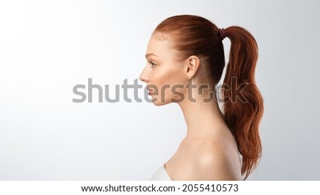 Side view portrait of teenager girl with ponytail hairstyle posing looking aside on gray studio background. Profile female headshot. Panorama with empty space for text Royalty-Free Stock Photo #2055410573