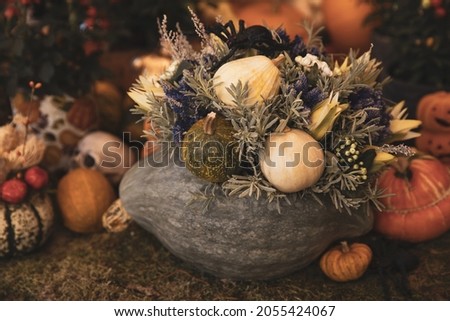 Decorated Halloween pumpkin on the table in the greek garden shop. October, 2021.