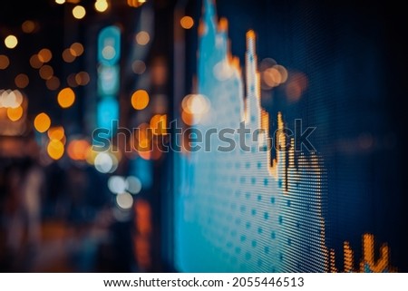 Display of Stock market quotes with city lights reflect on glass, small focus line