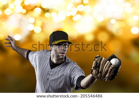 Baseball Player on a yellow Uniform on yellow lights background.