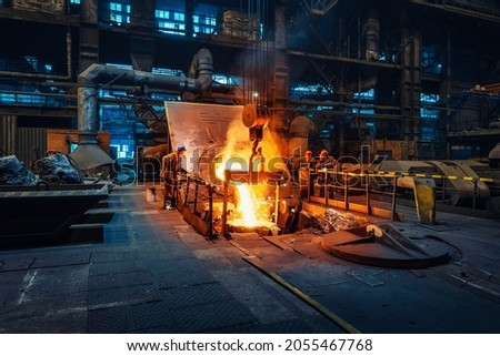 Metal cast process in blast furnace in metallurgical plant or factory. Liquid iron molten metal pouring in container, heavy industry background Royalty-Free Stock Photo #2055467768